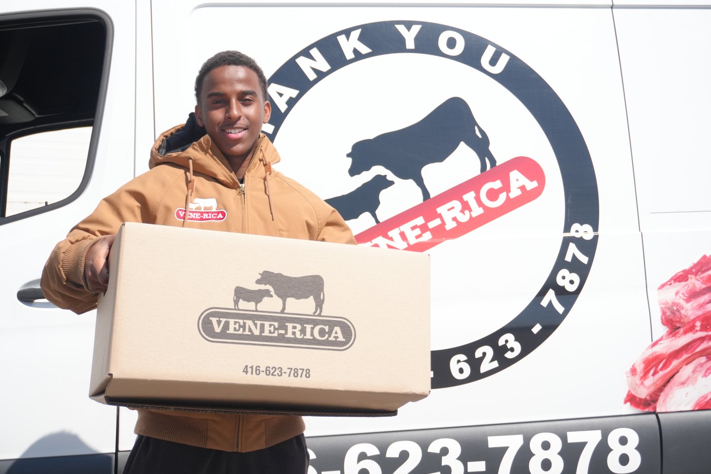 A Venerica delivery team member holding a branded order box beside a delivery van